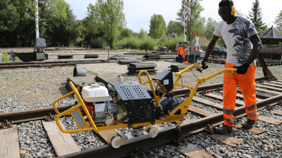 Auszubildender Gleisbau arbeiten mit vollhydraulischer Präzisionsschraubmaschine
